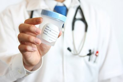 Physician holding urine sample cup Getty Images 172871012