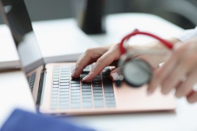 Physician typing on laptop Getty Images 1301570873