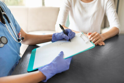 Provider with clipboard talking with patient Getty Images 2120564254