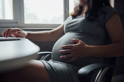 Pregnant pt at desk Getty Images 1246867332