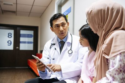Physician talking to woman and child Getty Images 978265078