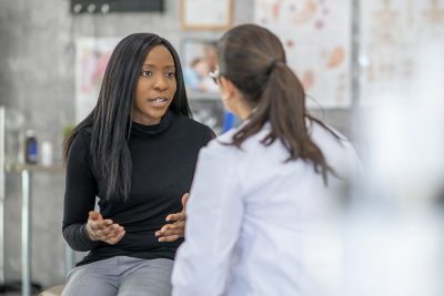 Young woman talking with physician Getty Images 1134371127